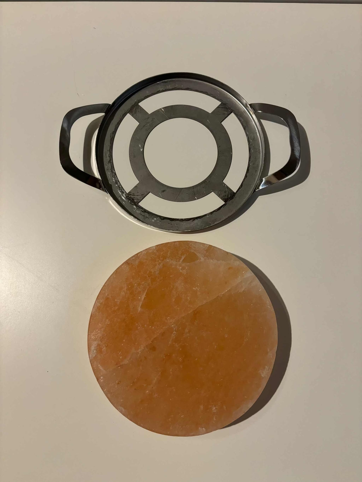 Ronde Himalaya zoutsteen kook-/serveerplaat met RVS frame, geschikt voor BBQ en oven, subtiele zoutsmaak.