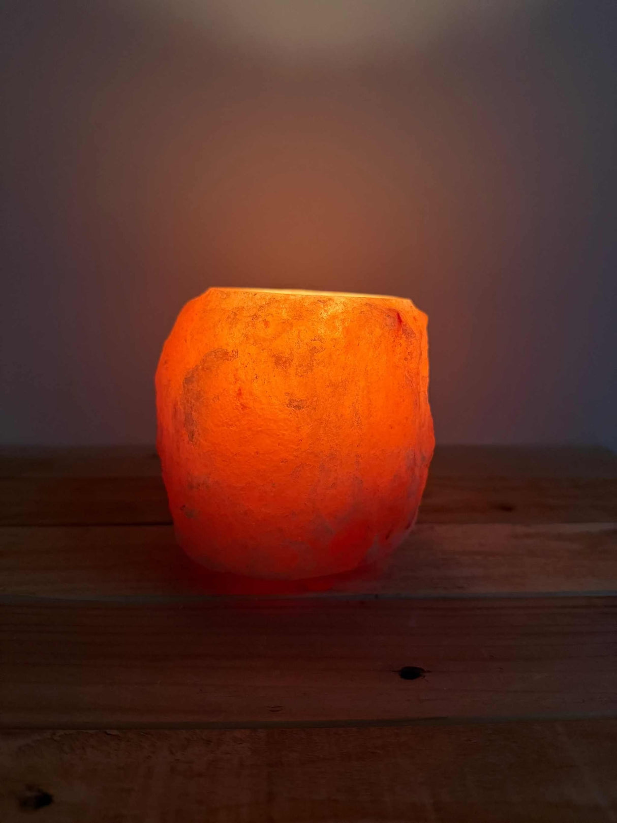 Handgemaakte natuurlijke zoutsteen waxinelichthouder rood met warme oranje gloed en siliconen voetjes