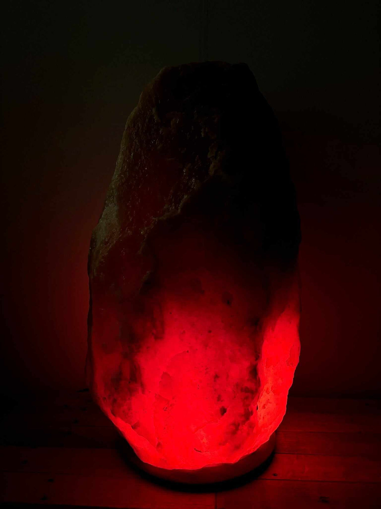 Himalaya Zoutlamp rood 60–70 kg met warme rood/oranje gloed en houten voet