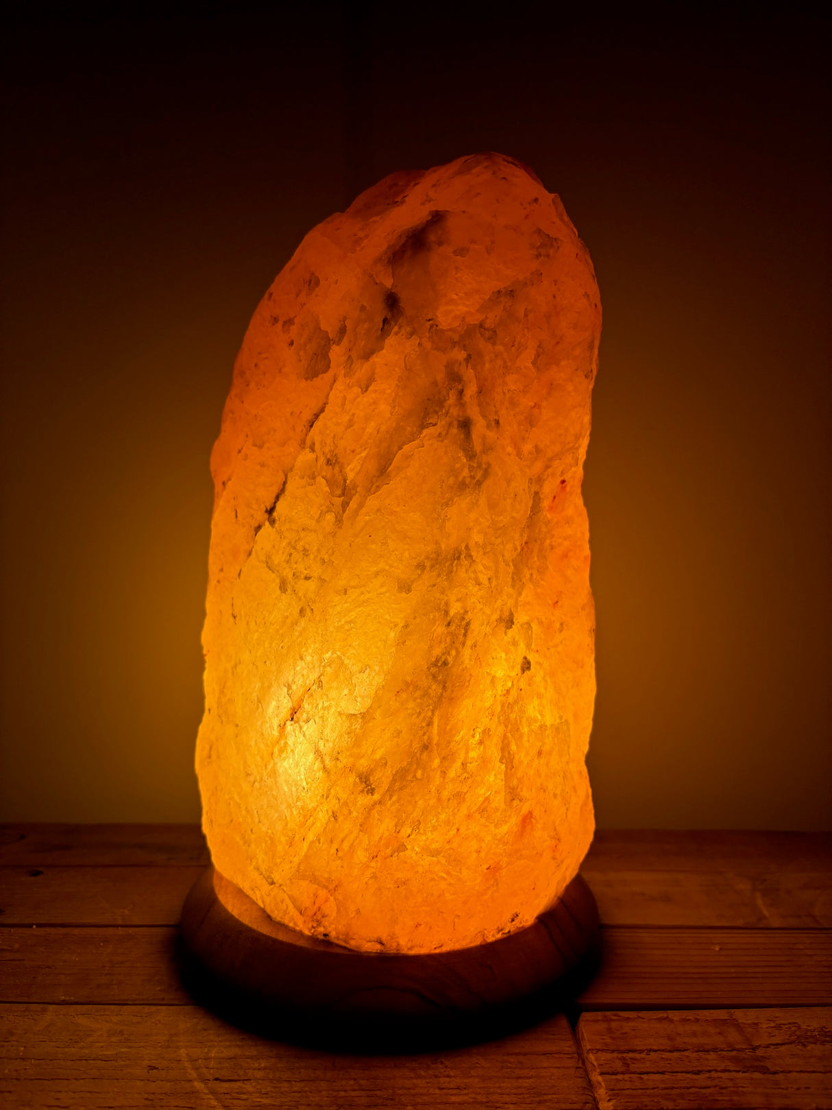 Grote Himalaya zoutlamp 10-12kg op houten voet, sfeerlicht en luchtzuivering voor woonkamers.