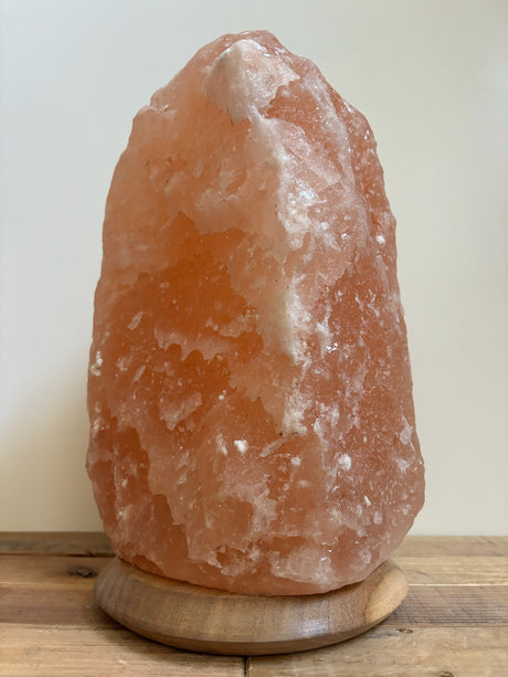 Himalaya zoutlamp 12-15kg, middelgroot  formaat met warme, natuurlijke gloed, op stevige houten voet.