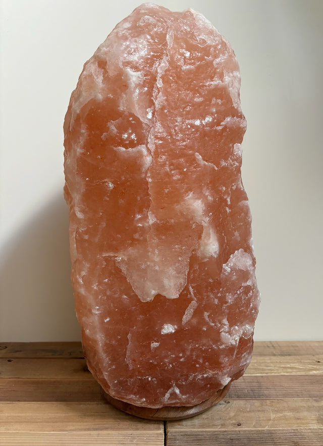 Grote Himalaya zoutlamp 30-35kg op houten voet, sfeervolle natuurlijke luchtzuiveraar voor woon- of bedrijfsruimte.
