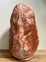 Himalaya zoutlamp 35-40kg, grote donker-roze zoutsteenlamp op houten voet voor wellness, ontvangstruimte of hotel.