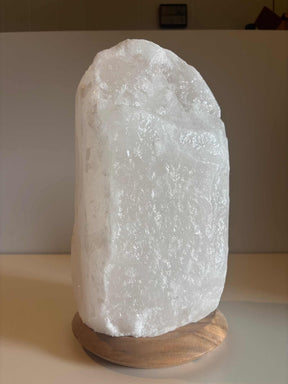 Witte Himalaya zoutlamp van 10-12 kg met houten voet, inclusief kabel en lampje, voor sfeervolle verlichting in huis.