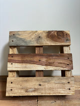Decoratieve houten pallet van duurzaam Sisso-hout, handgemaakt en geschikt als stevige basis voor woonaccessoires zoals zoutlampen.