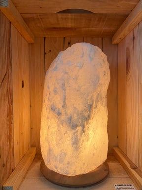 Brandende witte Himalaya zoutlamp 8-10 kg met natuurlijke structuur op houten voet