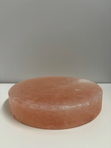 Ronde Himalaya zoutsteen kook- en serveerplaat van Ø20 cm, circa 4 kg. Natuurlijke roze steen geschikt voor warme bereidingen op BBQ of oven, en voor koude presentaties van sushi, kaas of desserts. Geeft gerechten een milde, subtiele zoutsmaak.