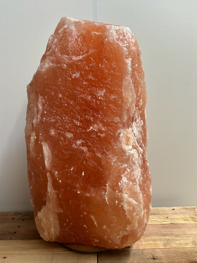 Himalaya XL zoutlamp 80–90 kg in zachte amberkleur op houten voet