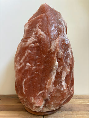 Donkere Himalaya zoutlamp 40–45 kg in natuurlijke diepe tinten op robuuste houten voet