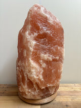 Lichte Himalaya zoutlamp 60–70 kg in natuurlijke roze tint op stevige houten voet