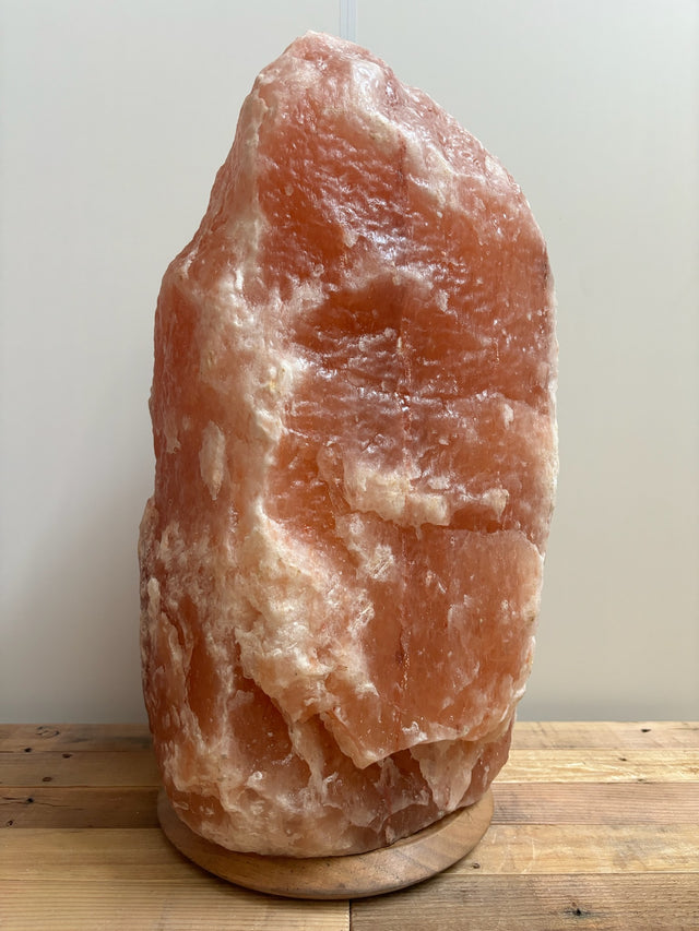 Lichte Himalaya zoutlamp 60–70 kg in natuurlijke roze tint op stevige houten voet