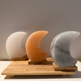 Handgemaakte Himalaya zoutlamp in maanvorm met zachte roze, grijze en witte gloed, inclusief kabel en reservelampje.