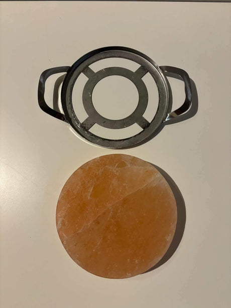 Ronde Himalaya zoutsteen kook-/serveerplaat met RVS frame, geschikt voor BBQ en oven, subtiele zoutsmaak.