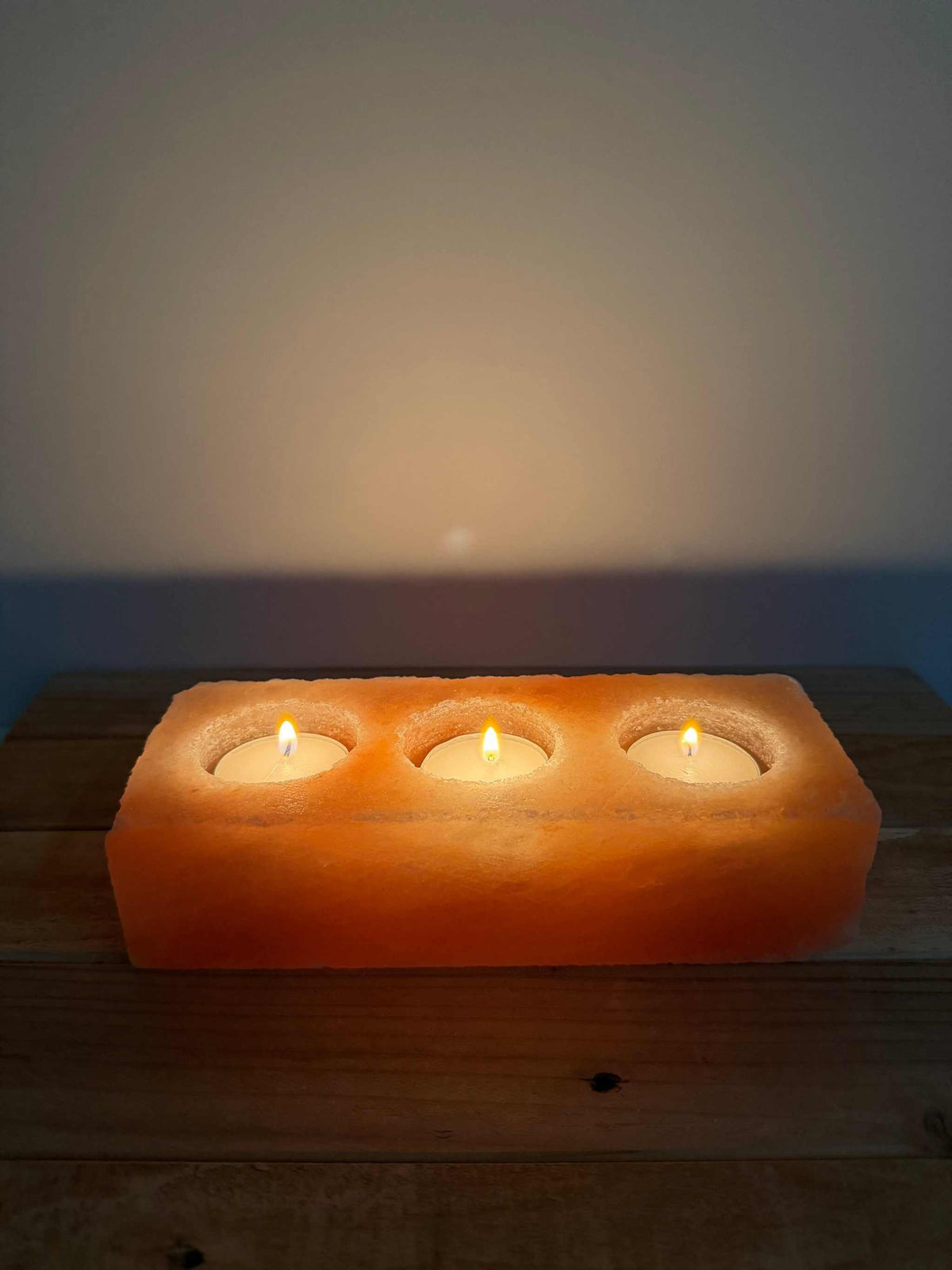 Brandende Himalaya zoutsteen waxinelichthouder rechthoek die warm oranje gloeit in het donker