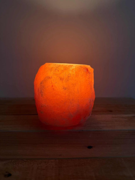 Handgemaakte natuurlijke zoutsteen waxinelichthouder rood met warme oranje gloed en siliconen voetjes