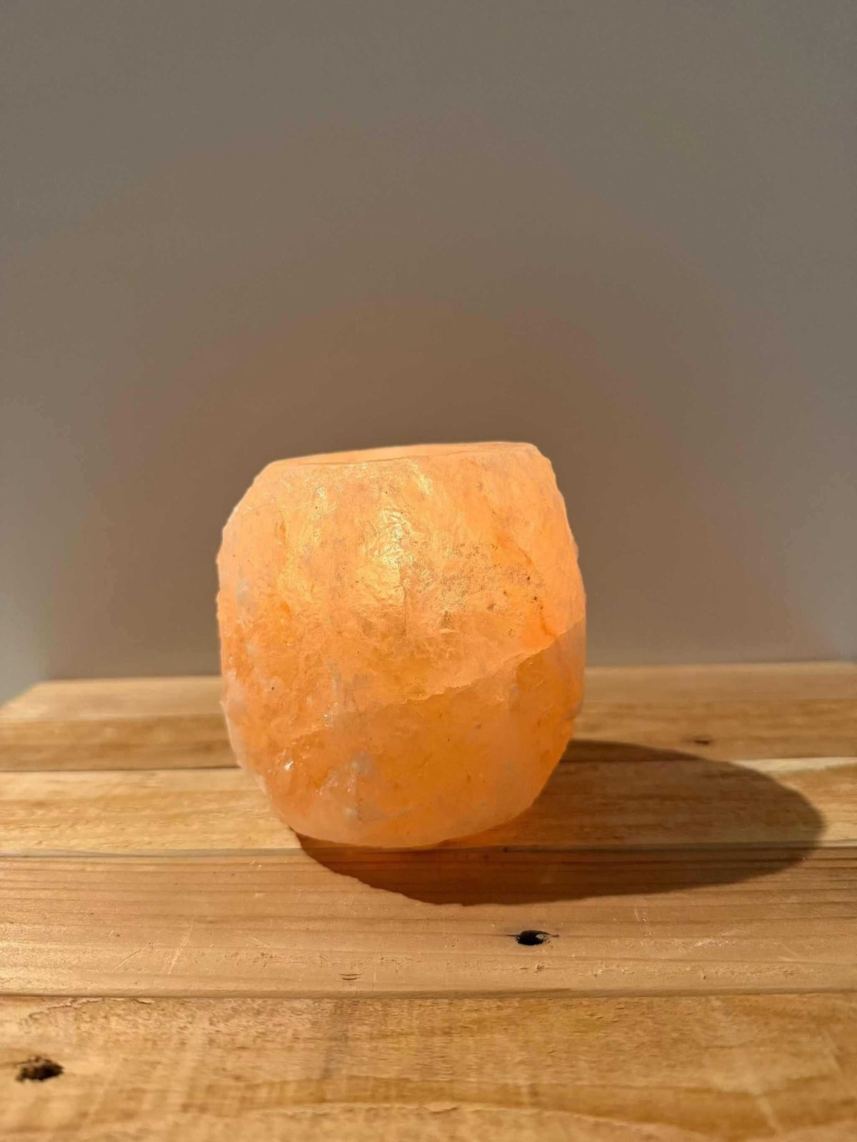 Handgemaakte roze waxinelichthouder van natuurlijke zoutsteen met warme gloed en siliconen voetjes.
